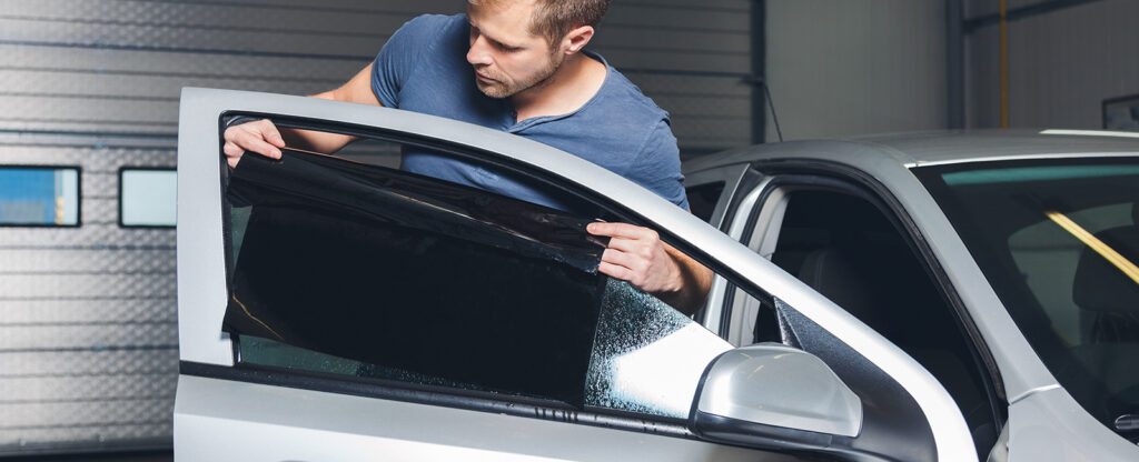 Otomobil camına profesyonel teknisyen tarafından ısı yalıtımlı cam filmi uygulama işlemi